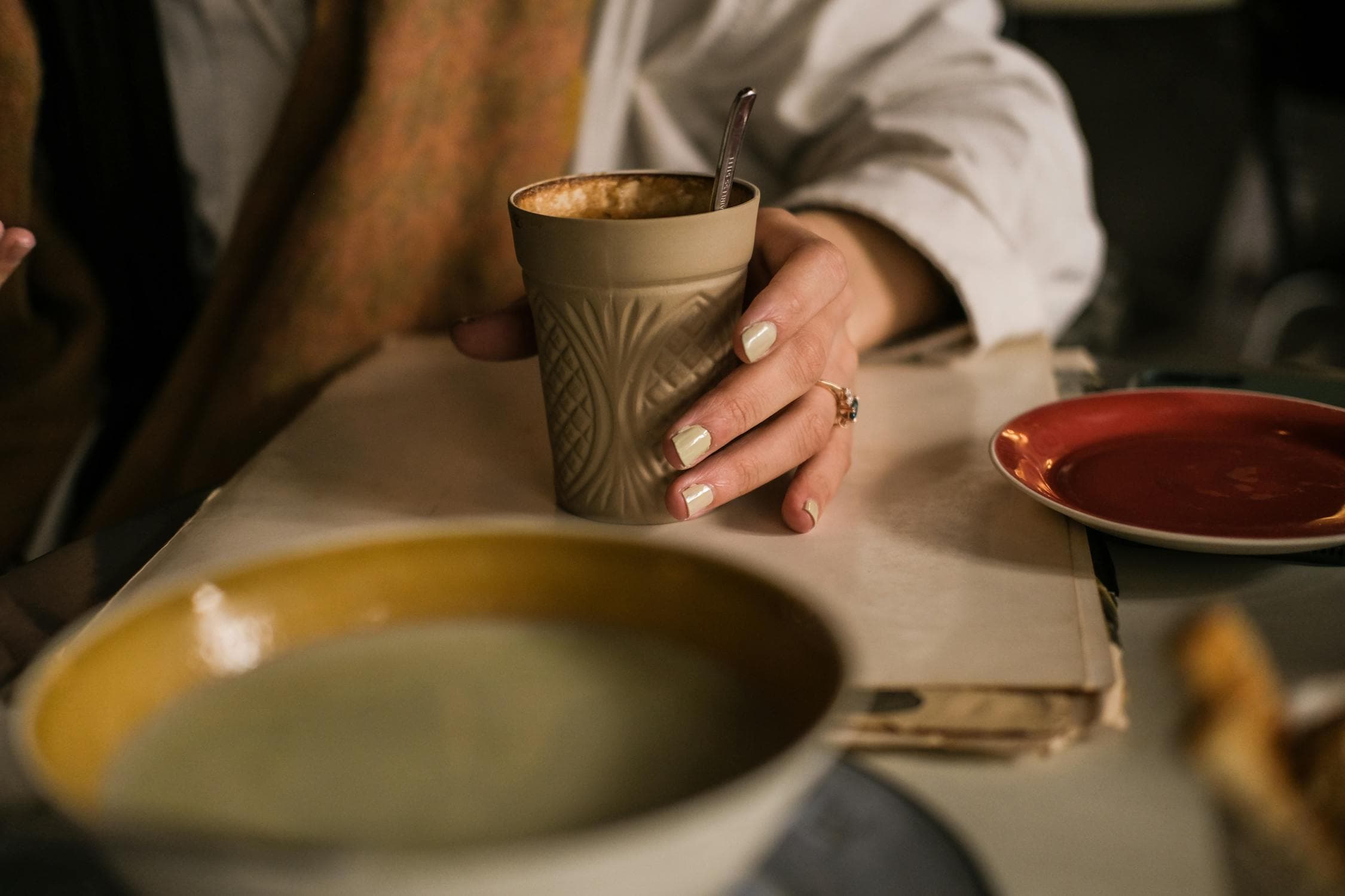 Hand holding a stoneware mug of coffee